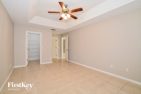 the living room has a ceiling fan and tile flooring