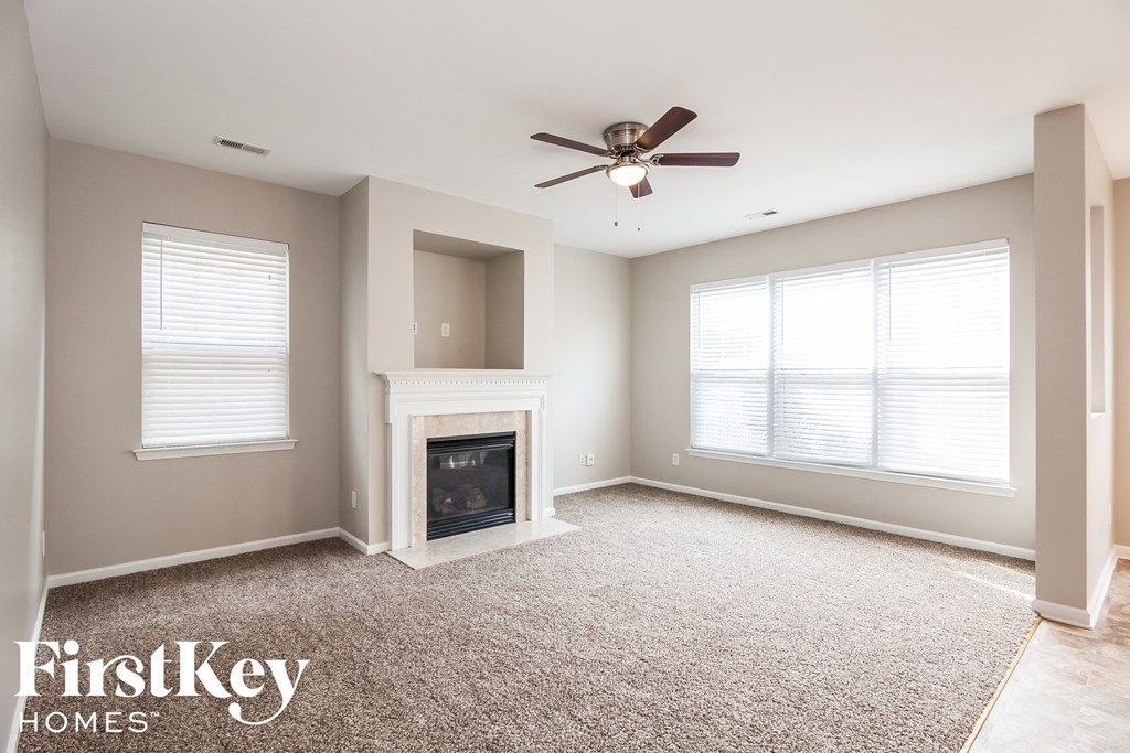 a living room with a fireplace and a ceiling fan
