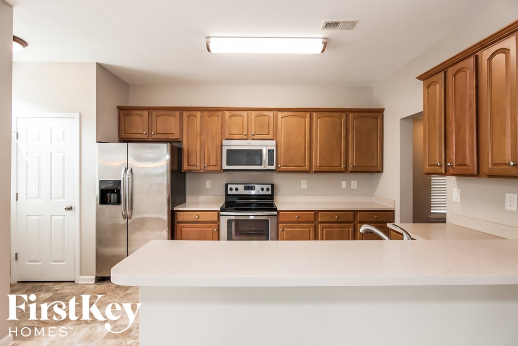 a kitchen with wooden cabinets and stainless steel appliances
