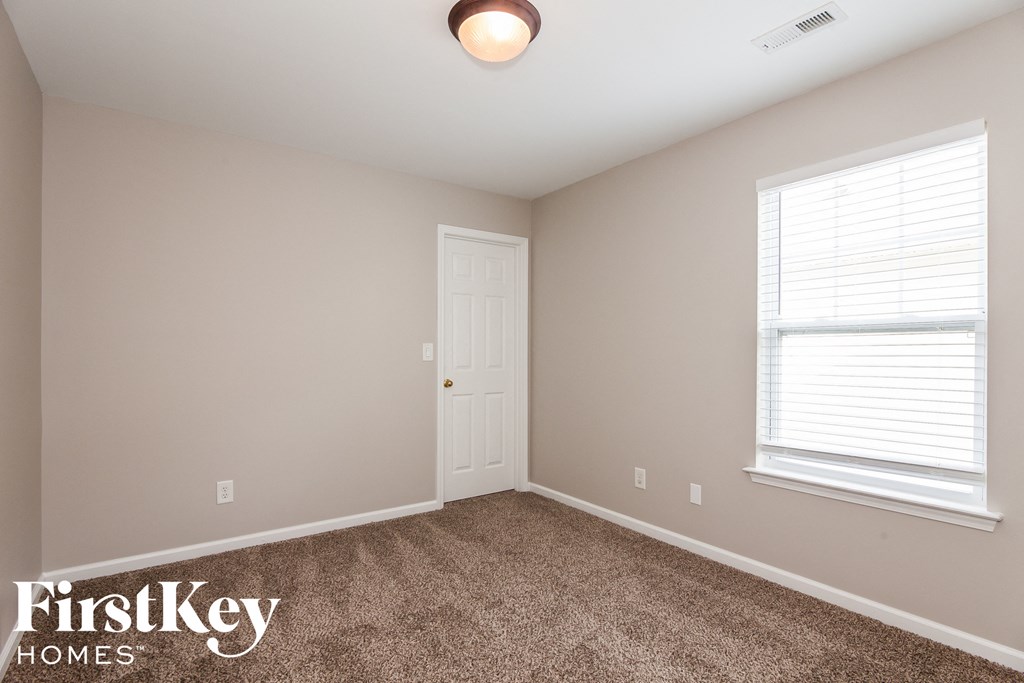 a bedroom with a carpeted floor and a white door