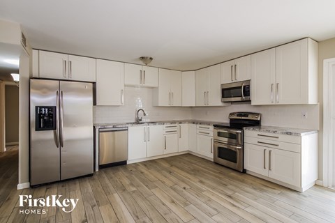 a kitchen with white cabinets and stainless steel appliances