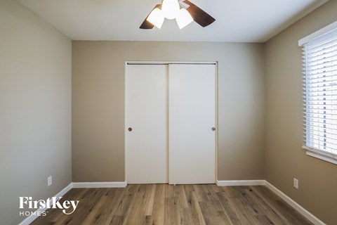 a bedroom with a closet and a ceiling fan