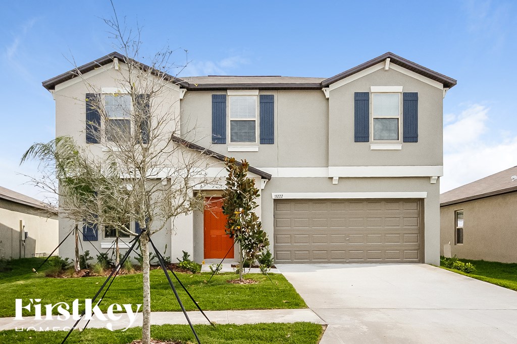 a new house with a garage door and a lawn