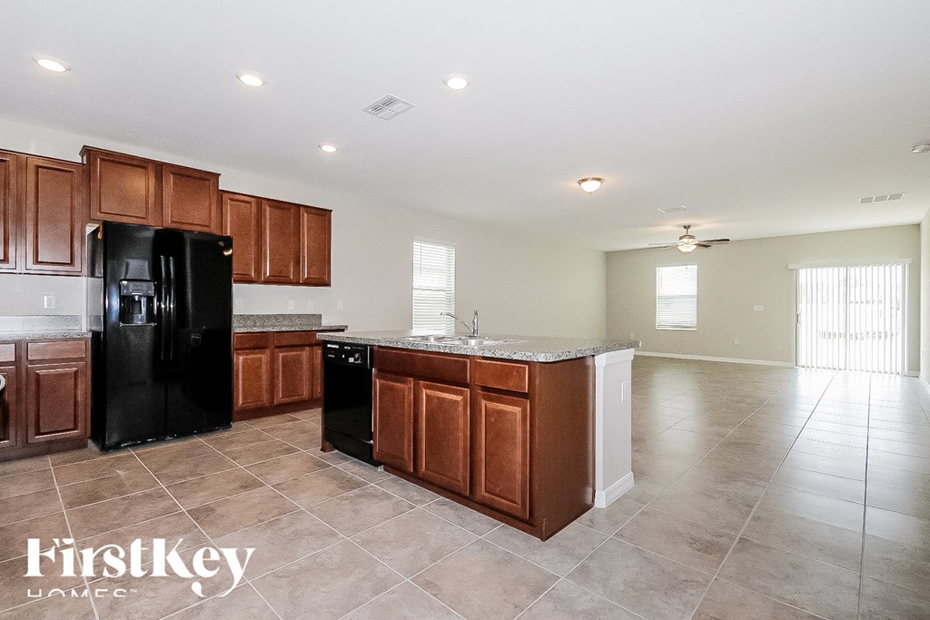 a kitchen with wooden cabinets and a black refrigerator