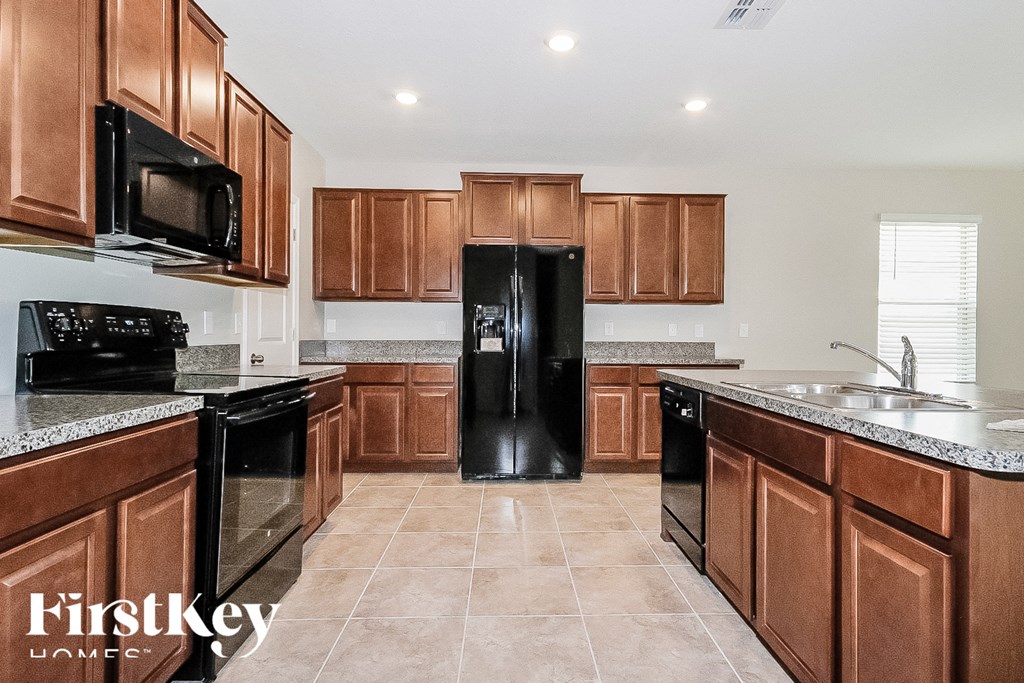 a kitchen with black appliances and wooden cabinets