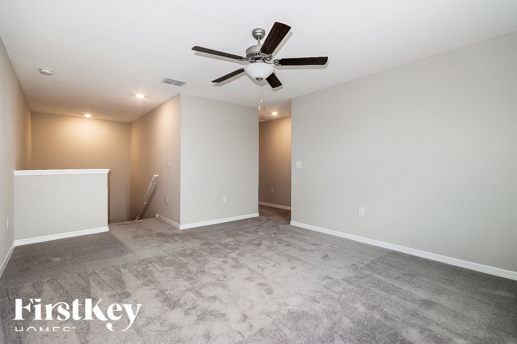 a empty living room with a ceiling fan