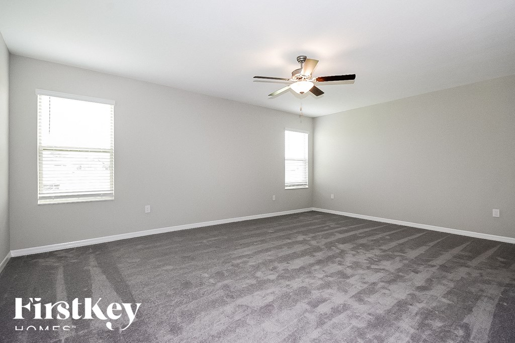 the living room of an empty house with a ceiling fan