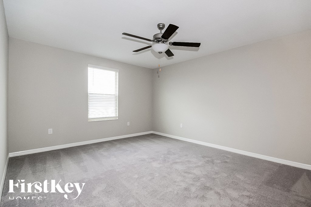 a empty room with a ceiling fan and a window