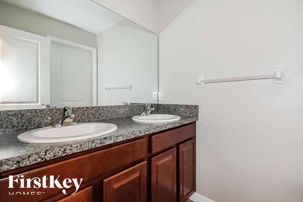 a bathroom with two sinks and a large mirror