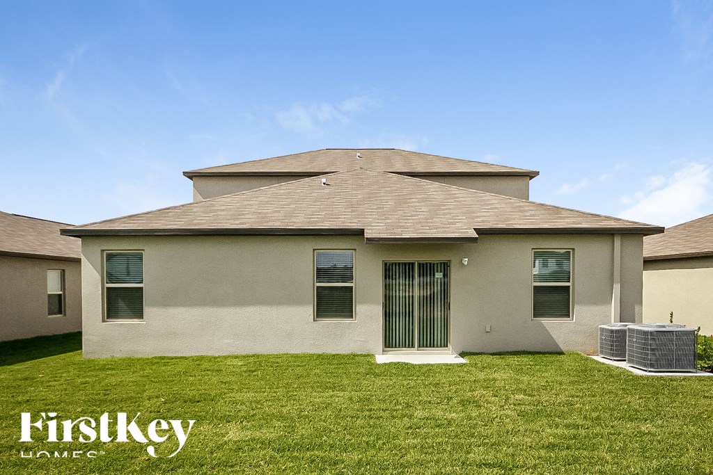 a house with a grassy yard and a blue sky