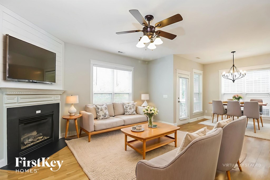 A living room with a fireplace and a flat screen TV mounted above it.