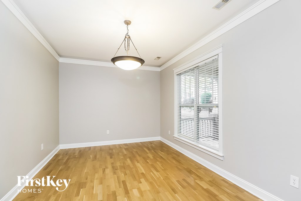 A room with wooden floors and a hanging light fixture.