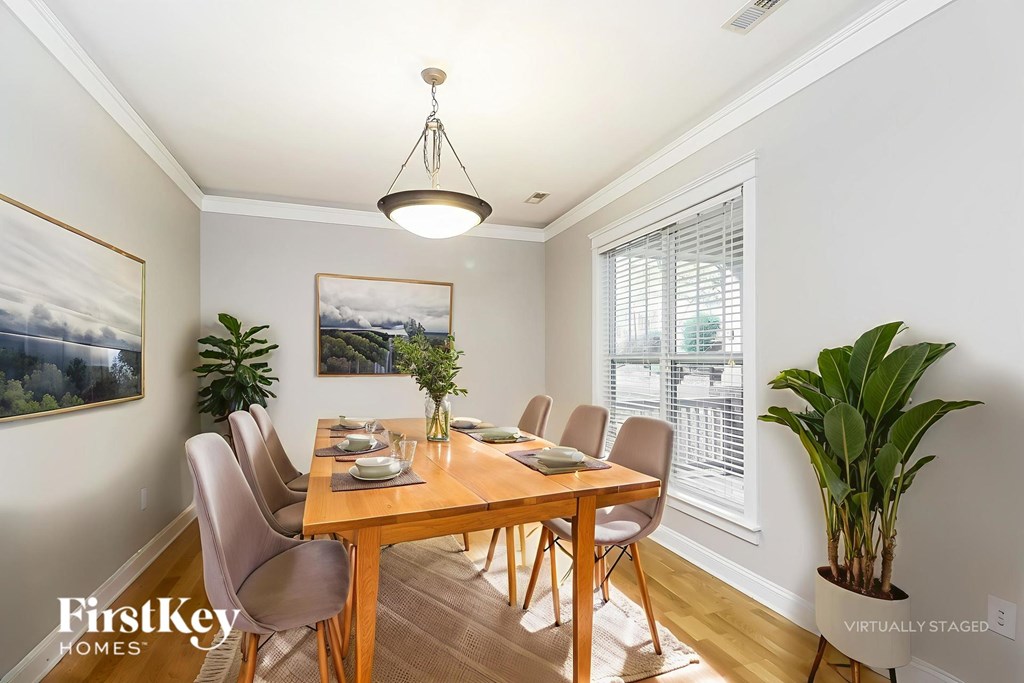 A dining room with a wooden table and chairs.