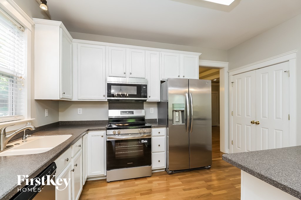 A kitchen with a stainless steel refrigerator and oven.