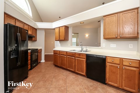 A kitchen with brown cabinets and black appliances.