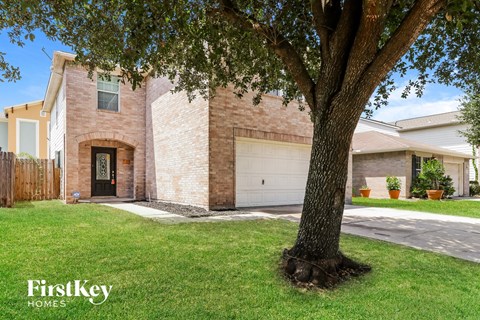 A tree in front of a house with the words "FirstKey Homes" on the bottom left.