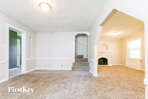 A spacious room with a staircase leading to the second floor.
