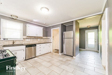 A kitchen with a stove top oven and a refrigerator.