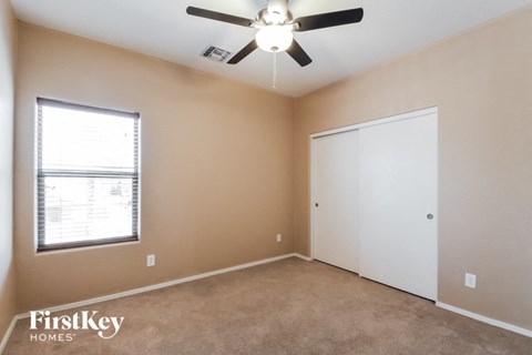 a bedroom with a ceiling fan and a window