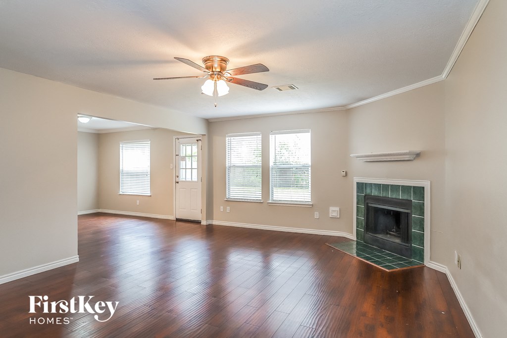 A room with a fireplace and a ceiling fan.