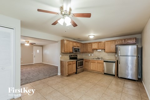 A kitchen with wooden cabinets and a refrigerator.