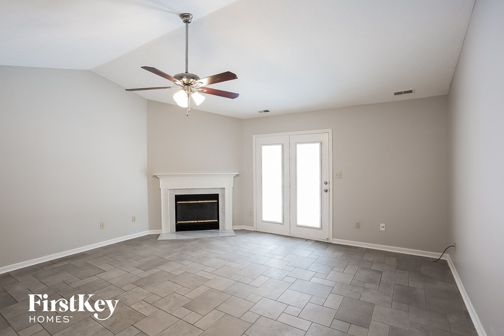 A room with a fireplace and a ceiling fan.