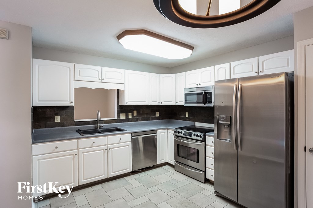 A kitchen with a stainless steel refrigerator, oven, and microwave.