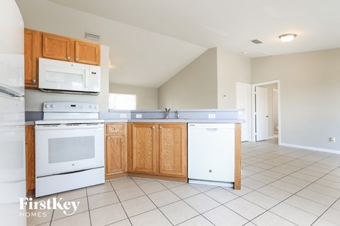 A kitchen with wooden cabinets and white appliances.