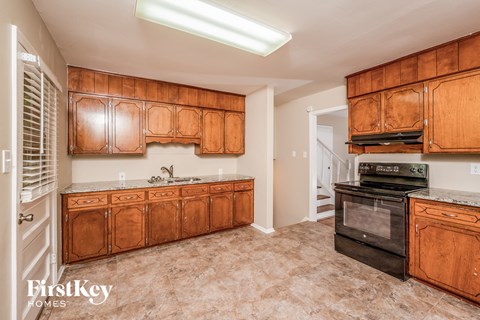 A kitchen with wooden cabinets and a black oven.