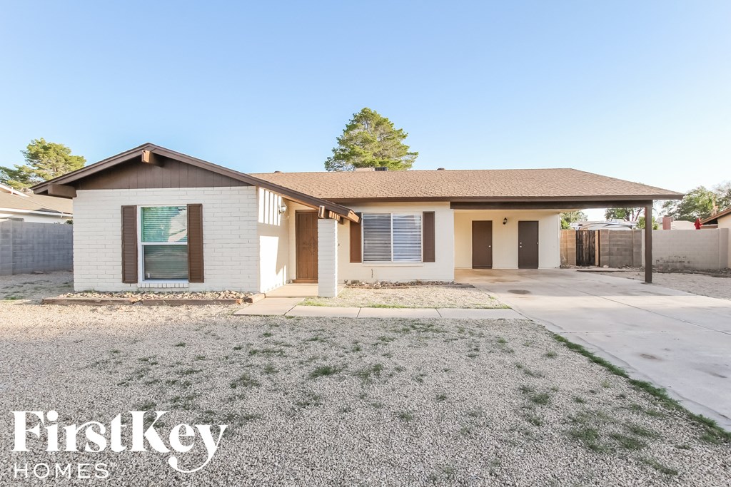 a small white house with a sidewalk and a driveway