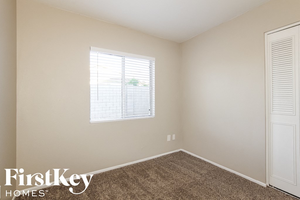 a bedroom with carpet and a window