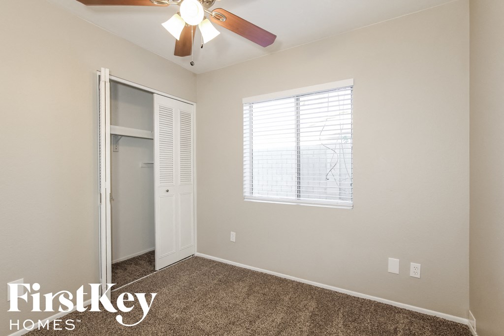 a bedroom with a ceiling fan and a closet