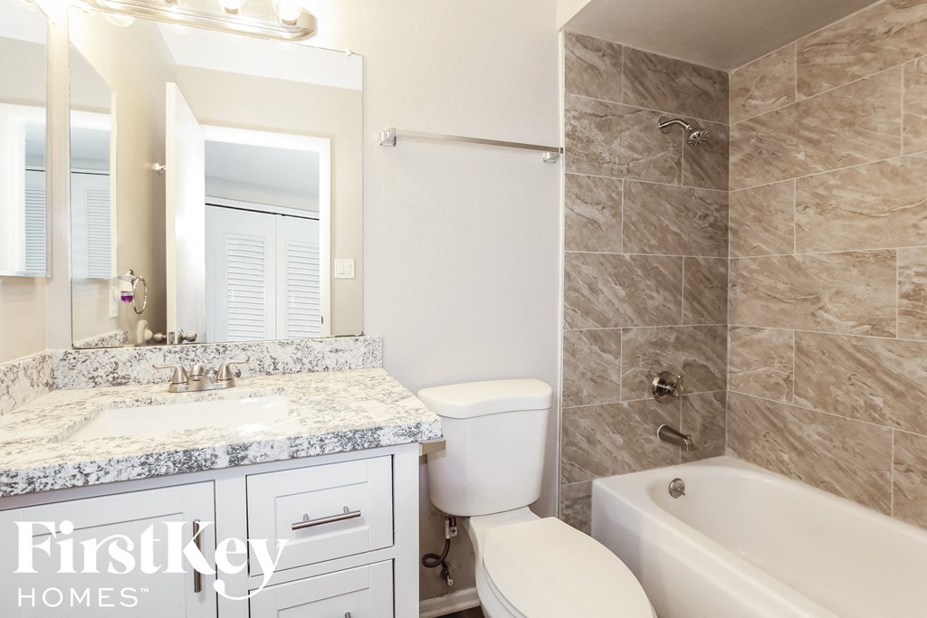 a bathroom with a sink toilet and tub and a mirror
