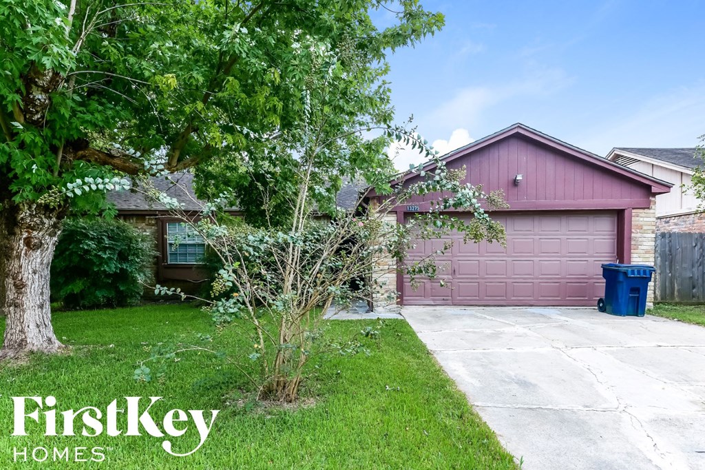 a house with a pink garage and a tree in the yard