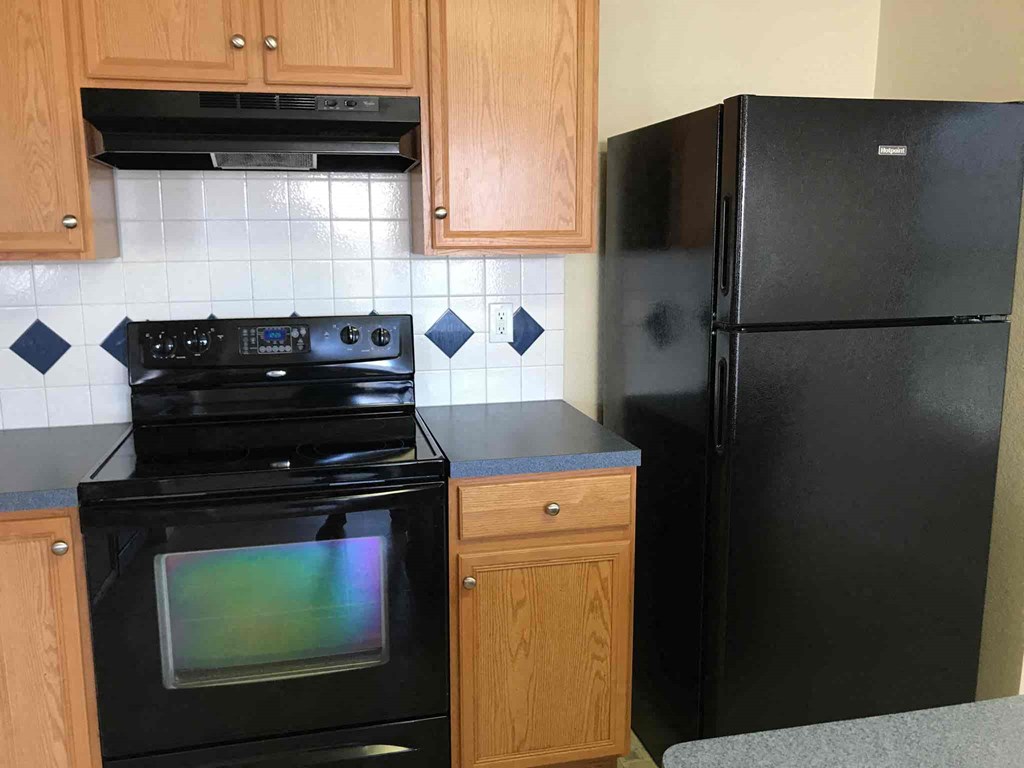 a kitchen with black appliances and wooden cabinets