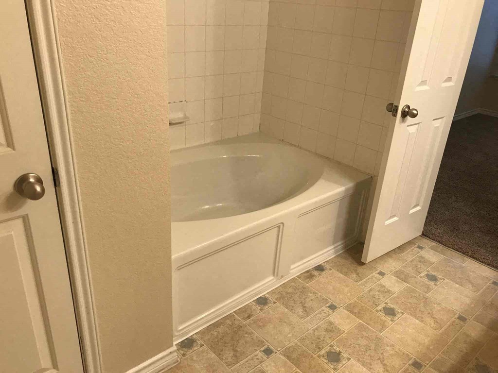 a bathroom with a bath tub and a door