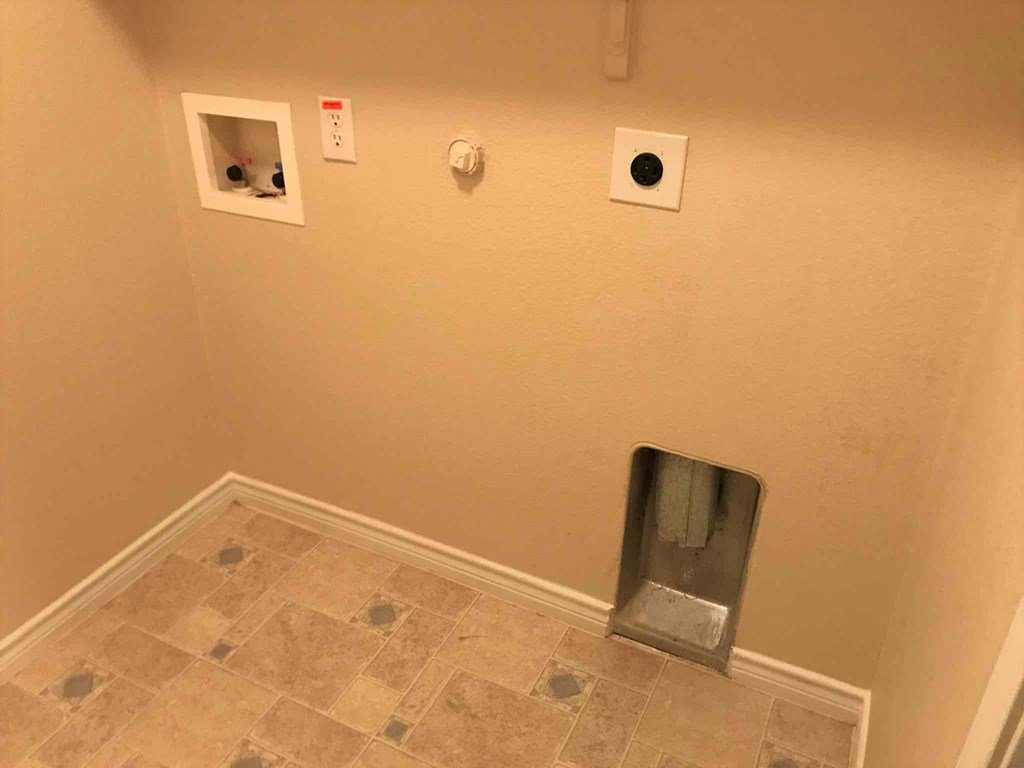 a wall with three outlets and a urinal in a room