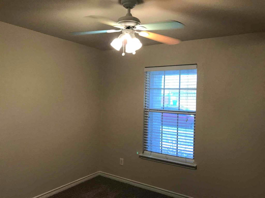 a bedroom with a ceiling fan and a window