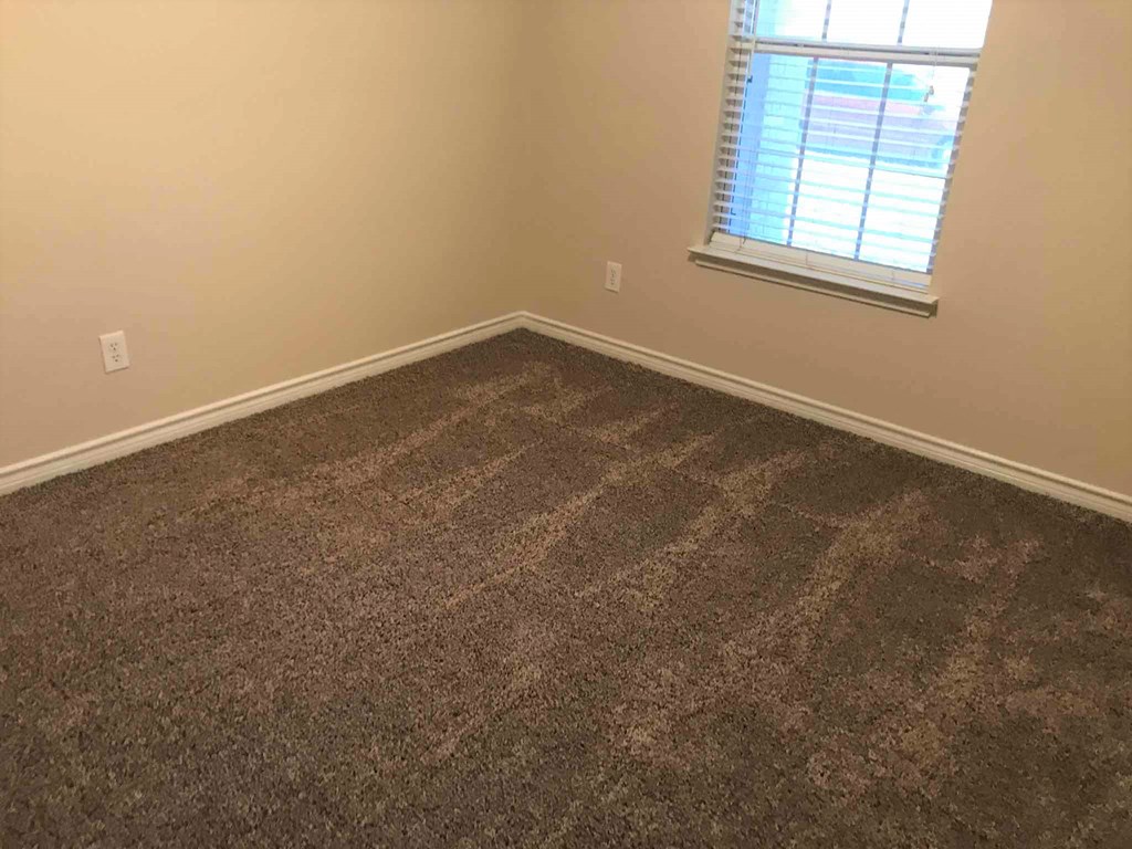 a room with a carpeted floor and a window