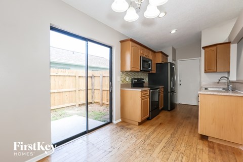 A kitchen with wooden cabinets and black appliances.