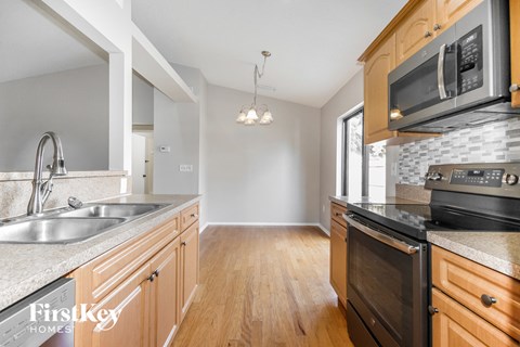 A kitchen with wooden cabinets and a stove top oven.