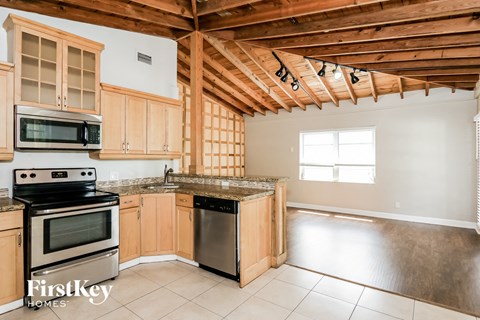 A kitchen with wooden cabinets and a stove top oven.