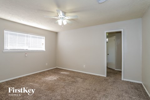 a bedroom with carpet and a ceiling fan