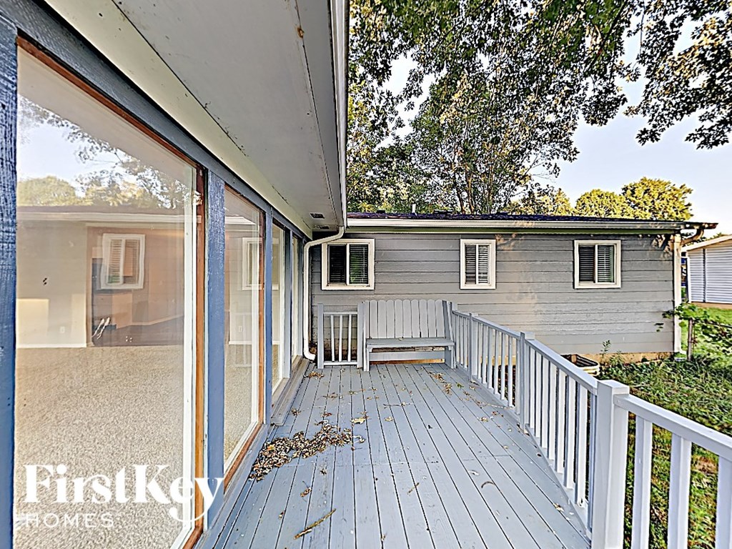 a white house with a porch with a bench on it