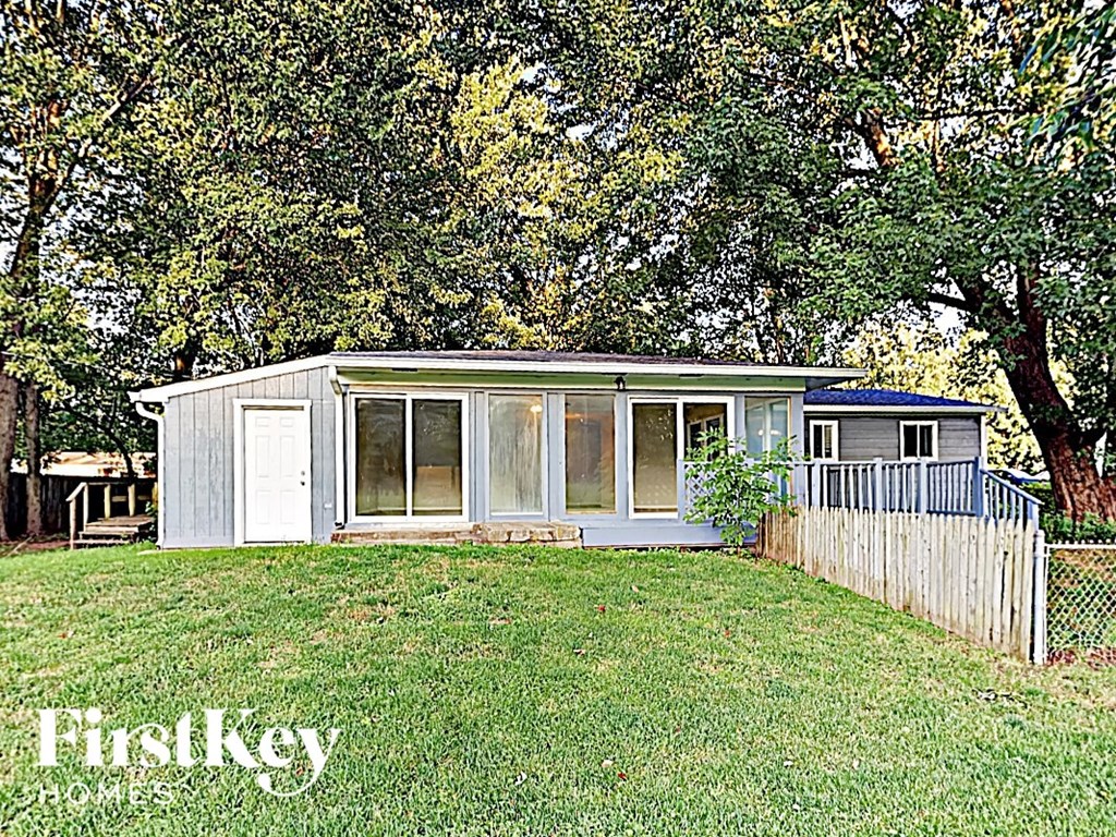 a tiny house in a backyard with a lawn and trees