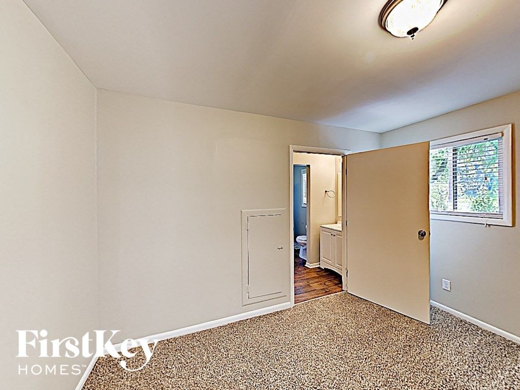 an empty bedroom with a door to the bathroom