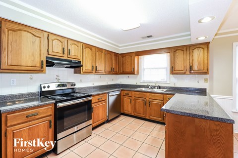 a kitchen with wooden cabinets and a stove and a sink