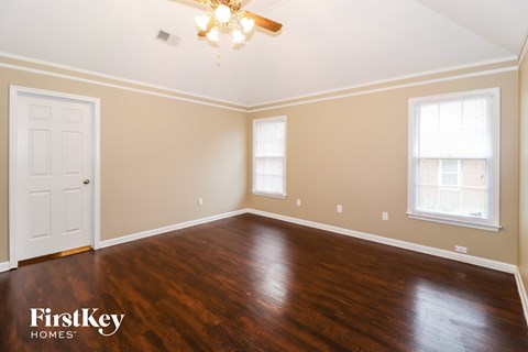 the living room of a home with wood floors and a ceiling fan