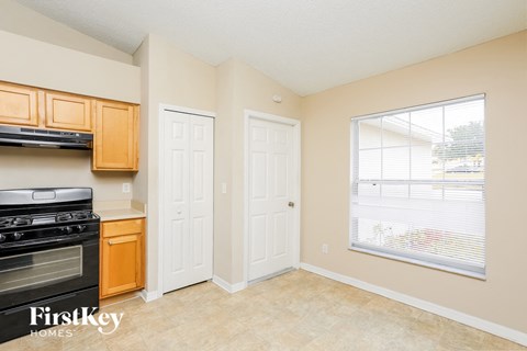 A kitchen with a black stove top oven and wooden cabinets.