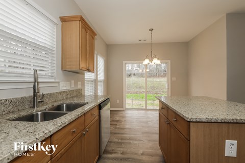 A kitchen with wooden cabinets and a granite countertop.